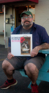 Owner holding an album while sitting outside. 