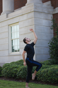 Boy doing ballet in front of a building 